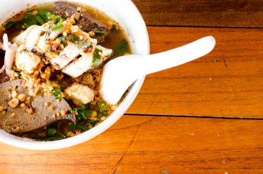 Baharatlı erişte ve ahşap arka plan üzerinde beyaz bir kase. Favori 