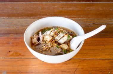 Baharatlı erişte ve ahşap arka plan üzerinde beyaz bir kase. Favori 