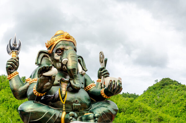 Green Ganesha Hindu God statue close up on natural background