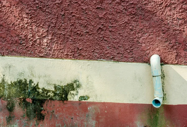 Resíduos de tubos ou drenagem ambiente poluente na parede vermelha — Fotografia de Stock