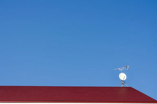 Satelit hidangan di atap dan langit biru — Stok Foto