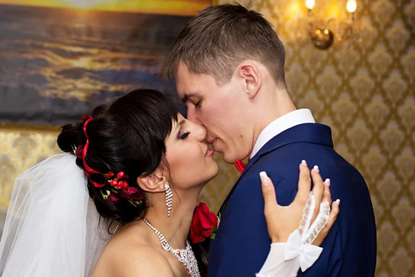 De bruid en bruidegom kussen — Stockfoto