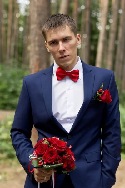 O noivo com um buquê de rosas — Fotografia de Stock