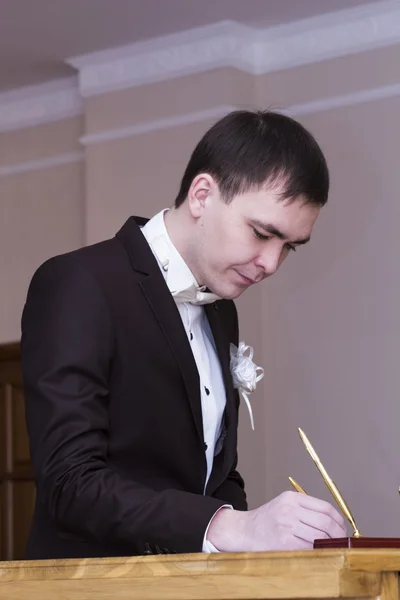 The groom puts his signature — Stock Photo, Image