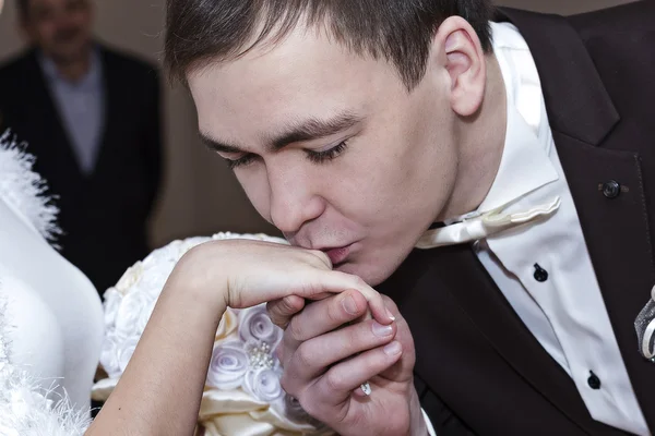 The groom kisses the bride's hand — Stock Photo, Image