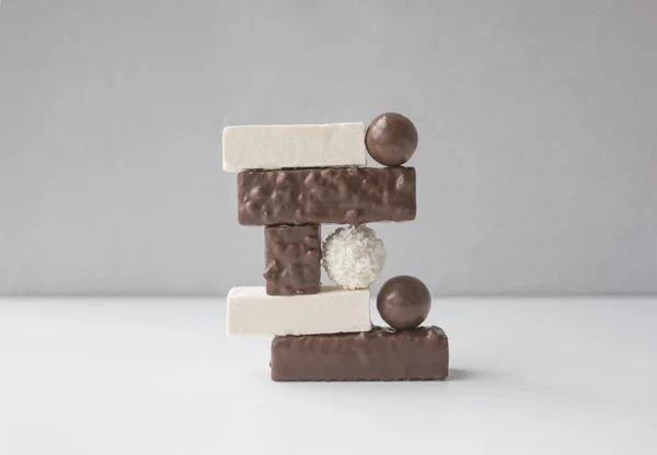 Caramelos, malvaviscos y obleas dispuestas sobre fondo blanco contra pared gris. Concepto de arte y diseño de alimentos. — Foto de Stock