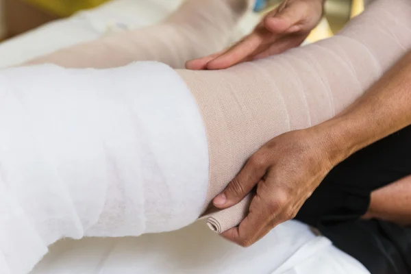 Nogi kobieta bandaging pacjenta — Zdjęcie stockowe