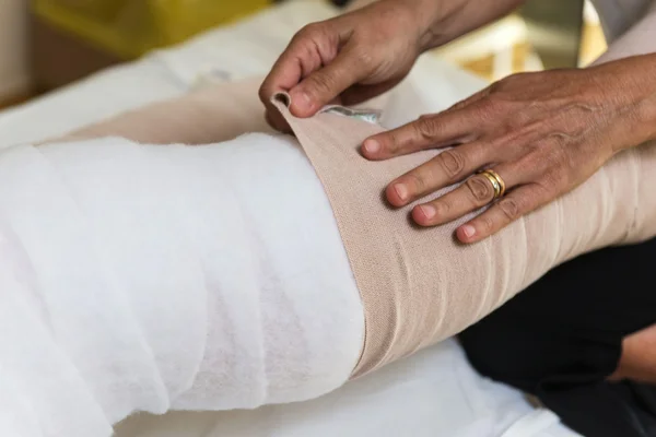 Nogi kobieta bandaging pacjenta — Zdjęcie stockowe