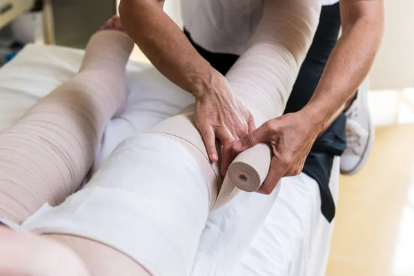 Nogi kobieta bandaging pacjenta — Zdjęcie stockowe