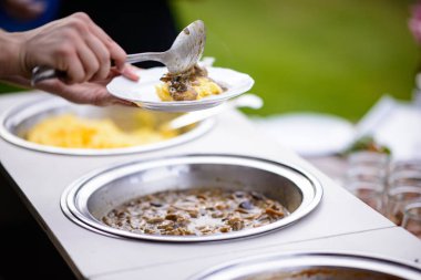 Yemekleri tabağa koyan eller.