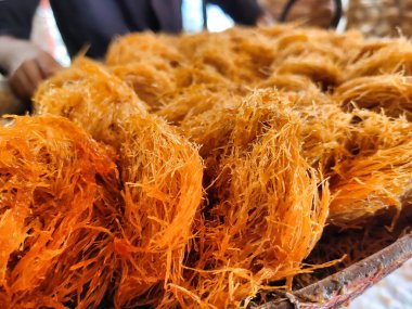Hint alt kıtasındaki Pheniyaan adlı altın sarısı vermicelli tatlısının yakın plan çekimi gündüz vakti Makar Sankranti şenliğinde satışa sunuldu.