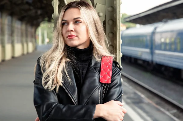 Tren istasyonunda deri ceketli güzel bir sarışının portresi..
