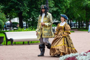 Russia, St. Petersburg - August 31, 2020: Actors in the robes of Emperor Peter 1 and Empress Catherine 2 pose for a tourist photographer clipart