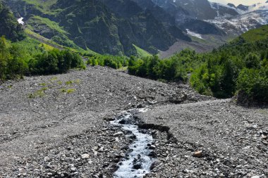 Tsey buzulu sıcak bir yaz gününde erir ve birçok büyük ve küçük dereler oluşturur, Kuzey Osetya, Rusya