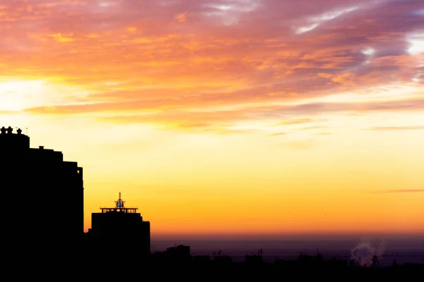 The sun rises over a large city in winter. Beautiful winter sunrise