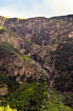 Kuzey Osetya 'daki büyük ve küçük nehirler ve şelaleler görkemli dağların arka planına karşı. Kuzey Osetya Cumhuriyeti - Alania