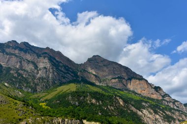 Kuzey Kafkasya 'nın güzel dağ zirveleri mavi bulutlu gökyüzünün arka planına karşı. Kuzey Osetya Cumhuriyeti - Alania