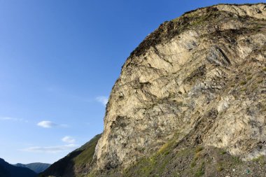 Kuzey Kafkasya 'nın güzel dağ zirveleri mavi bulutlu gökyüzünün arka planına karşı. Kuzey Osetya Cumhuriyeti - Alania