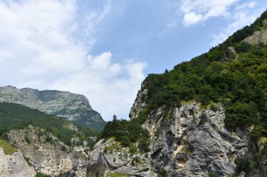 Kuzey Kafkasya 'nın güzel dağ zirveleri mavi bulutlu gökyüzünün arka planına karşı. Kuzey Osetya Cumhuriyeti - Alania