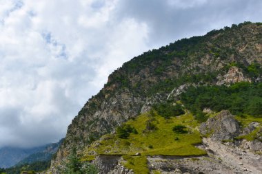 Kuzey Kafkasya 'nın güzel dağ zirveleri mavi bulutlu gökyüzünün arka planına karşı. Kuzey Osetya Cumhuriyeti - Alania