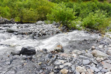 Kuzey Osetya 'daki büyük ve küçük nehirler ve şelaleler görkemli dağların arka planına karşı. Kuzey Osetya Cumhuriyeti - Alania
