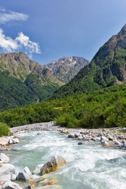 Kuzey Osetya 'daki büyük ve küçük nehirler ve şelaleler görkemli dağların arka planına karşı. Kuzey Osetya Cumhuriyeti - Alania