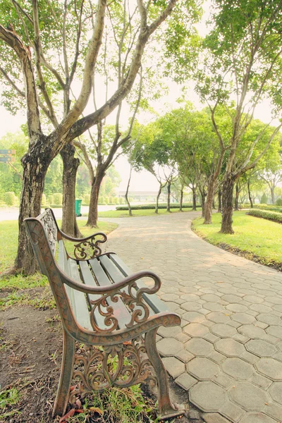 Banco bajo el árbol en los jardines — Foto de Stock