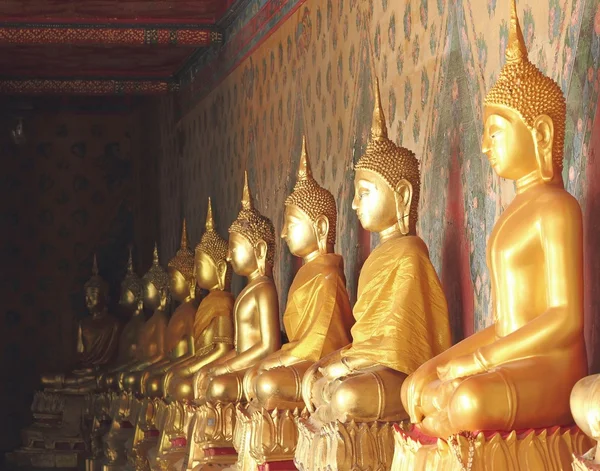 Altın Buda heykelleri ve giyinmiş sarı bornoz — Stok fotoğraf