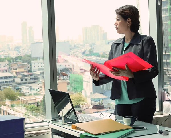 İş kadını pencereden dışarı bakıyor.