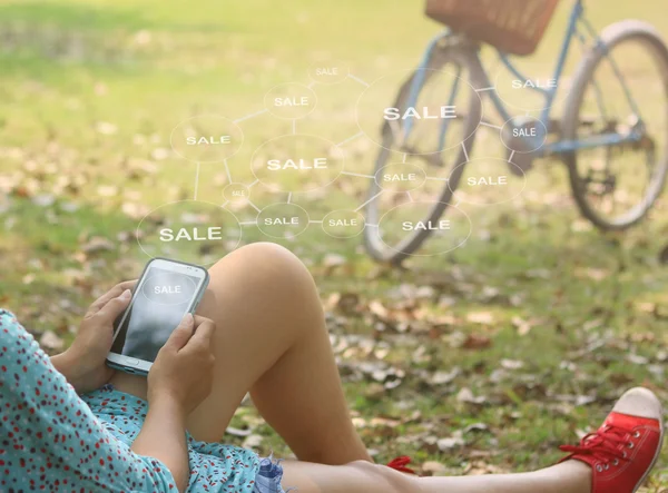 Женщина с помощью мобильного смартфона, продажа сенсорного экрана — стоковое фото