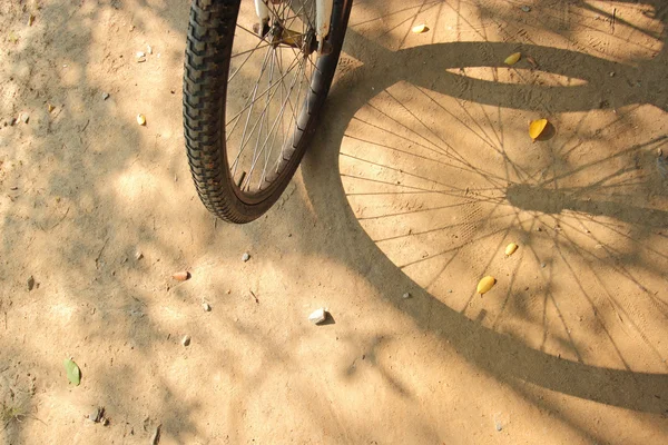 Λεπτομέρεια από ένα ποδήλατο και σκιά σε άμμο φόντο. — Φωτογραφία Αρχείου