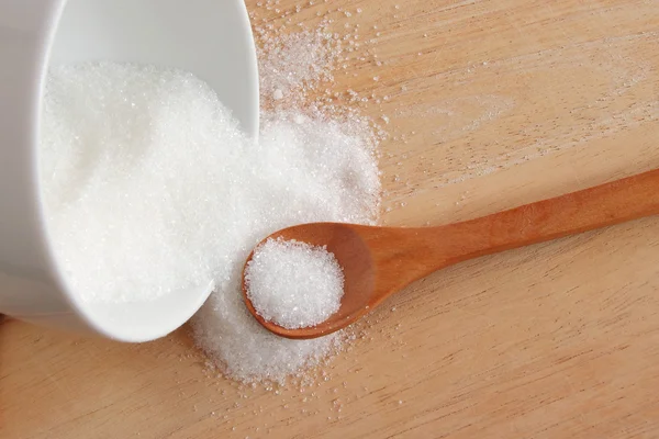 Açúcar branco na colher de madeira — Fotografia de Stock
