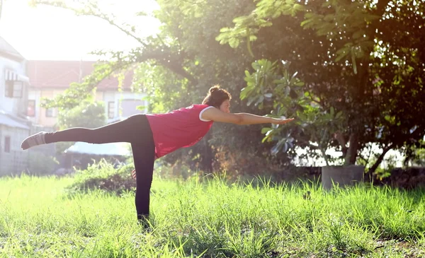 Elegante mujer de mediana edad haciendo yoga al aire libre Imagen de archivo