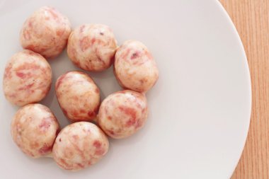 Beyaz çanak üzerinde çiğ sosis