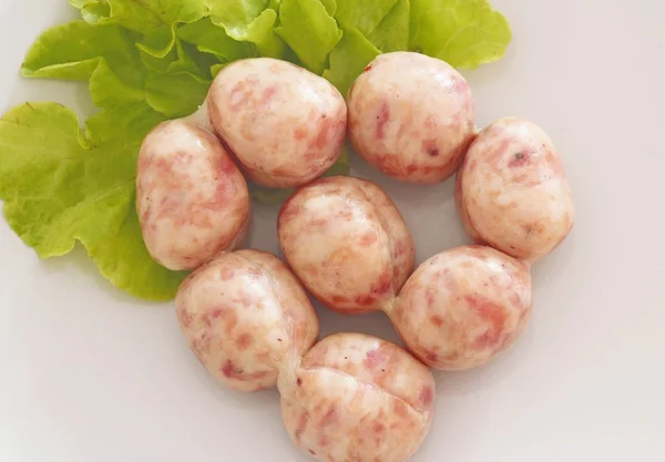 Raw sausage on white dish — Stock Photo, Image