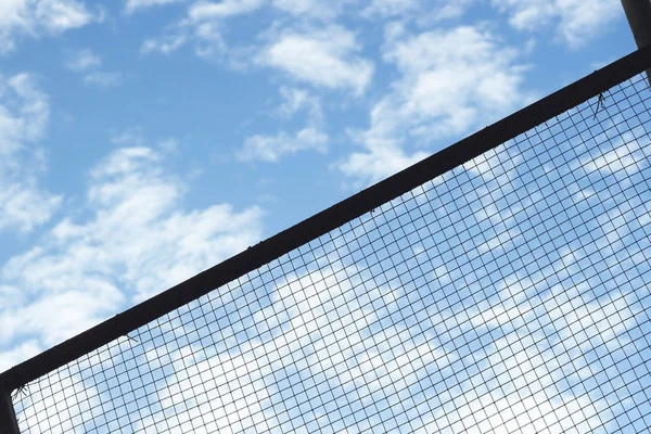 Silhouette of Structure mesh metal fence on sky background