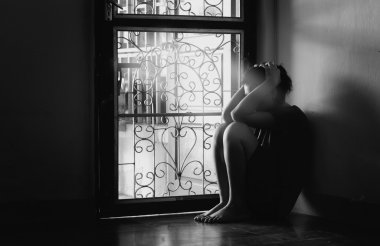 Yalnız boş bir odada oturan üzgün kadın