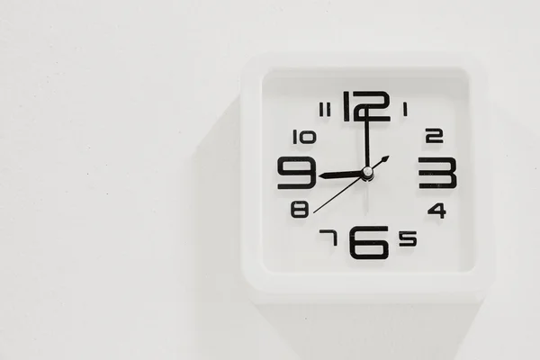 Reloj blanco suave sobre fondo de pared blanco — Foto de Stock