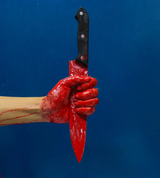 kanlı bir el tutarak büyük bir kan kaplı bıçak