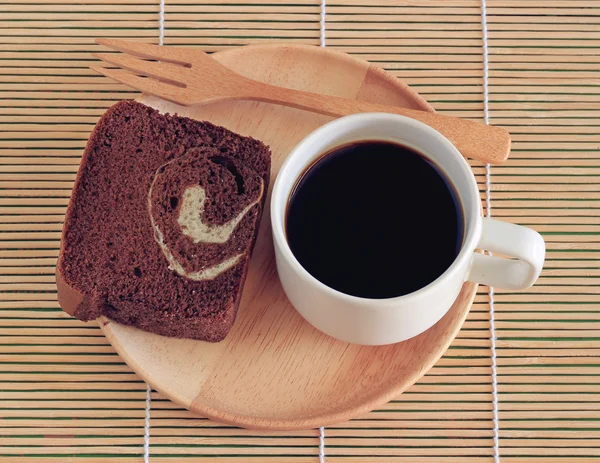 Koffiekopje en vers brood op schotel — Stockfoto