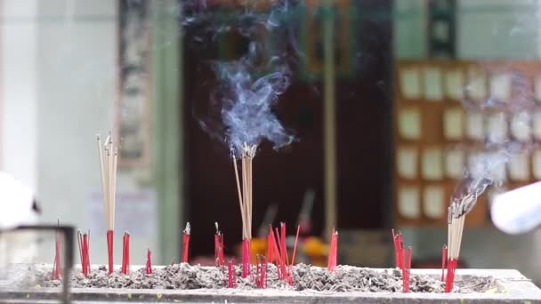 Dyrkan med rökelse och ljus inuti ett kinesiskt tempel. — Stockvideo