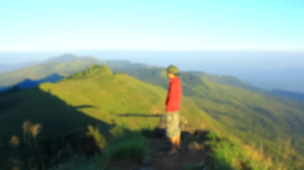 Uomo in cima alla montagna, sfocato per effetto presentazione, sfondo astratto — Foto Stock