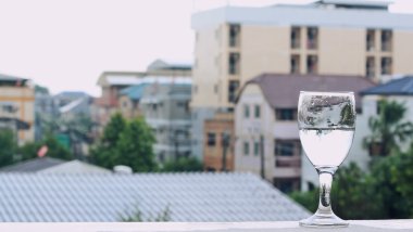 Bir yağmurlu günde şehir arka plan ile bir bardak su içmek.