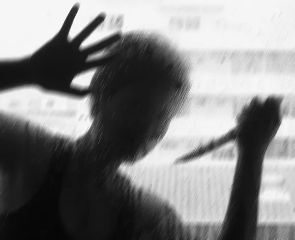 Cam arkasında bir bıçakla gölgeli resim