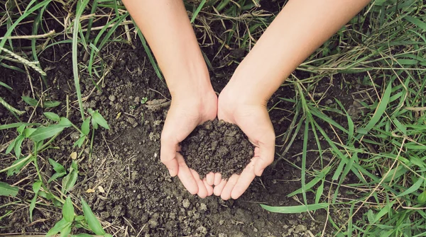 Female hands full of soil over soil background — Stock Photo, Image