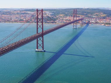 Ünlü Ponte 25 de Abril Köprüsü. 2 km uzunluğunda, kırmızı Golden Gate tarzı, Lizbon 'u Almada' ya bağlayan güzel asma köprü. Kral Meydanı İsa 'dan panoramik görüş. Lizbon 'da Akşam.