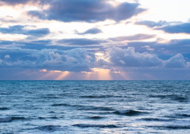 Güneş denizin üzerinden bulutların arasından doğuyor.