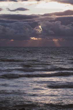 Güneş denizin üzerinden bulutların arasından doğuyor.