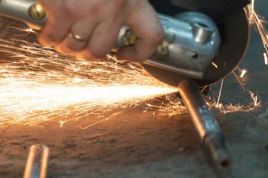 Demir keserken öğütücünün altından kıvılcımlar uçuşuyor. seçici odak