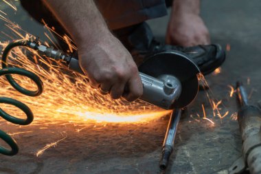 Bir adam elinde öğütücüyle kıvılcımlar saçar. seçici odak